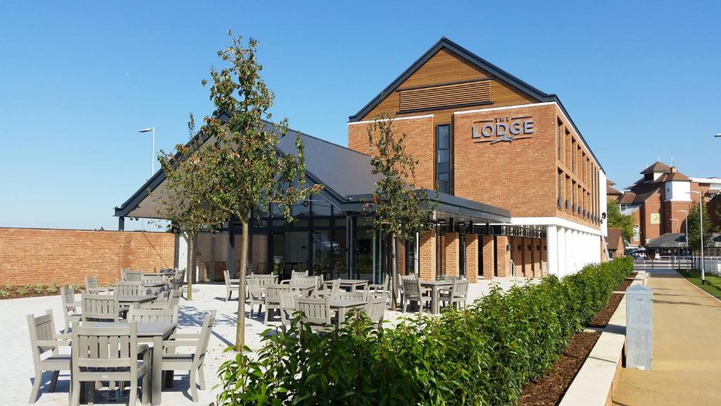 a group of white tables and chairs in front of a building at The Lodge in Newbury