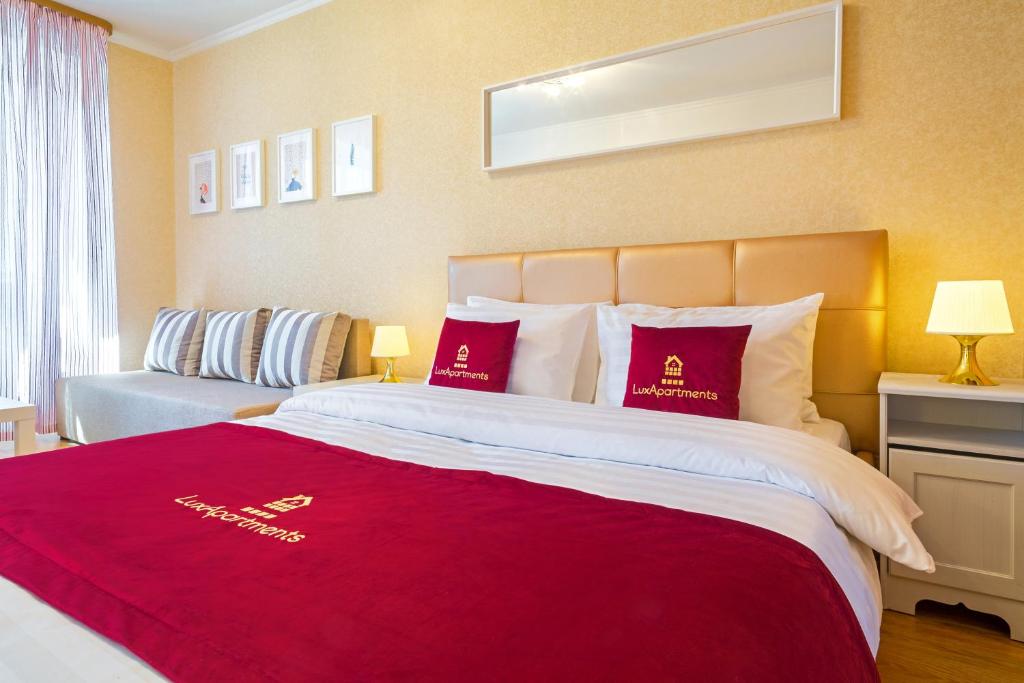 モスクワにあるLux-Apartments, улица Заморенова 14の大きなベッド(赤い枕付)が備わる客室です。