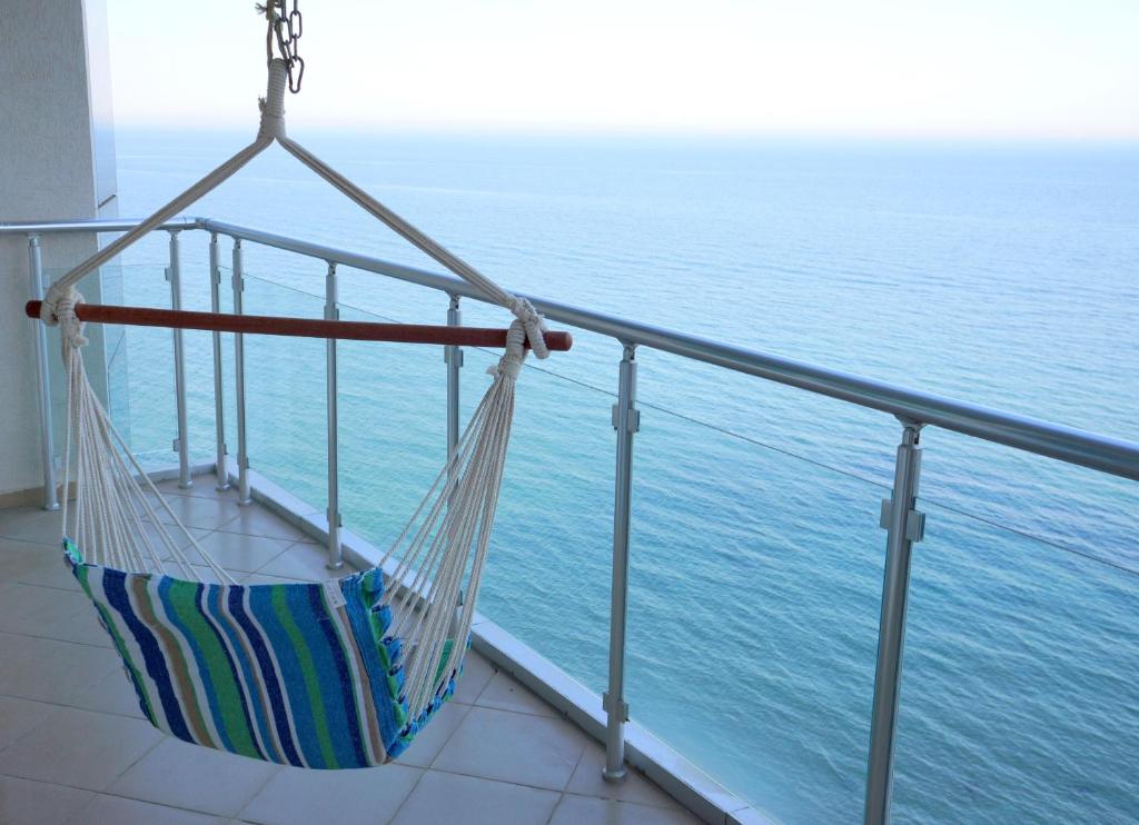 a hammock on a balcony overlooking the ocean at Silver Beach Delux Apartment in Byala