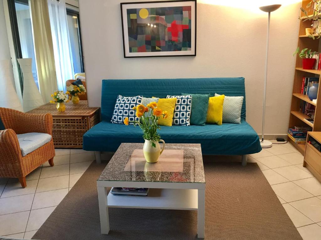 - un salon avec un canapé bleu et une table dans l'établissement Allées Provençales, à Aix-en-Provence