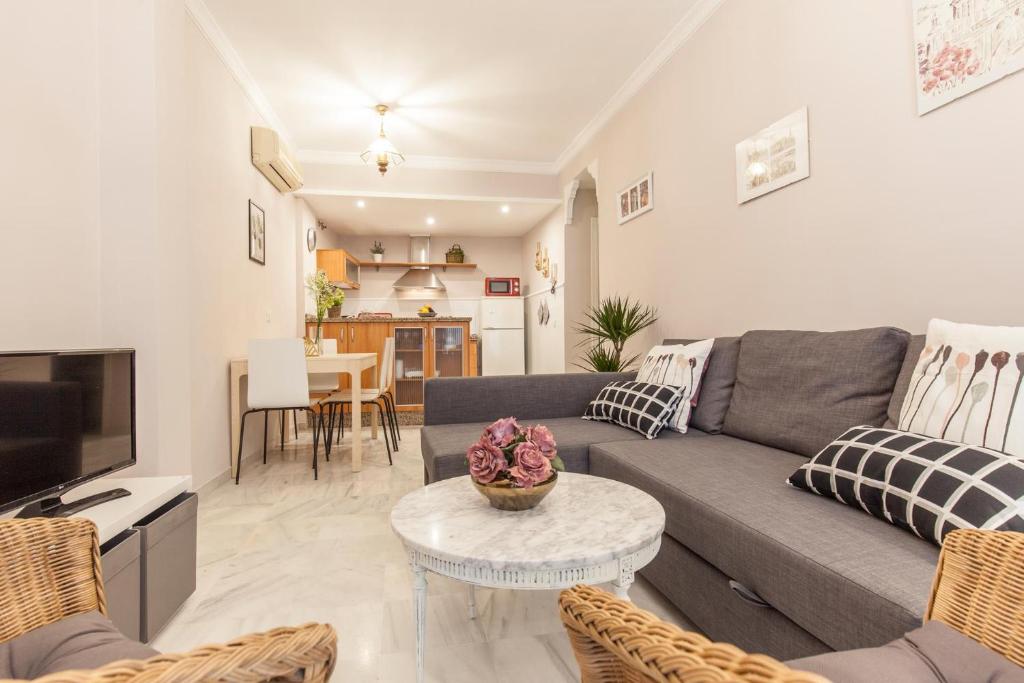 salon z kanapą i stołem w obiekcie Elegante apartamento en el corazon de Sevilla. w Sewilli