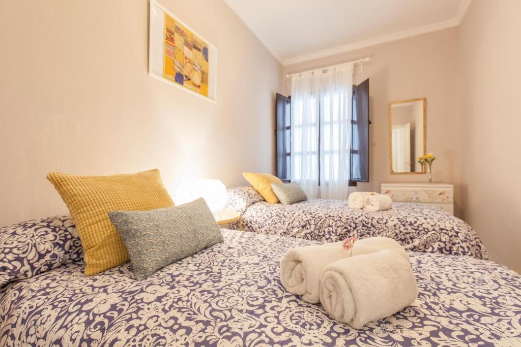 sypialnia z 2 łóżkami i ręcznikami w obiekcie Elegante apartamento en el corazon de Sevilla. w Sewilli