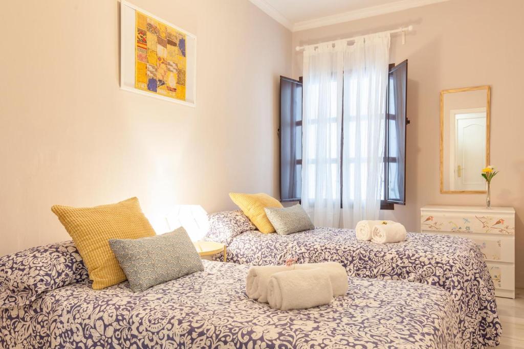 pokój z dwoma łóżkami i kanapą w obiekcie Elegante apartamento en el corazon de Sevilla. w Sewilli