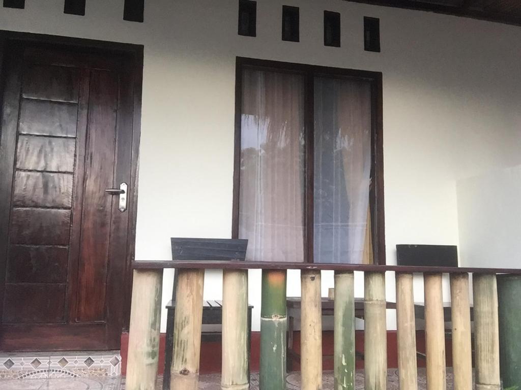 two doors on a house with a wooden fence at Tiu Kelep Homestay in Senaru