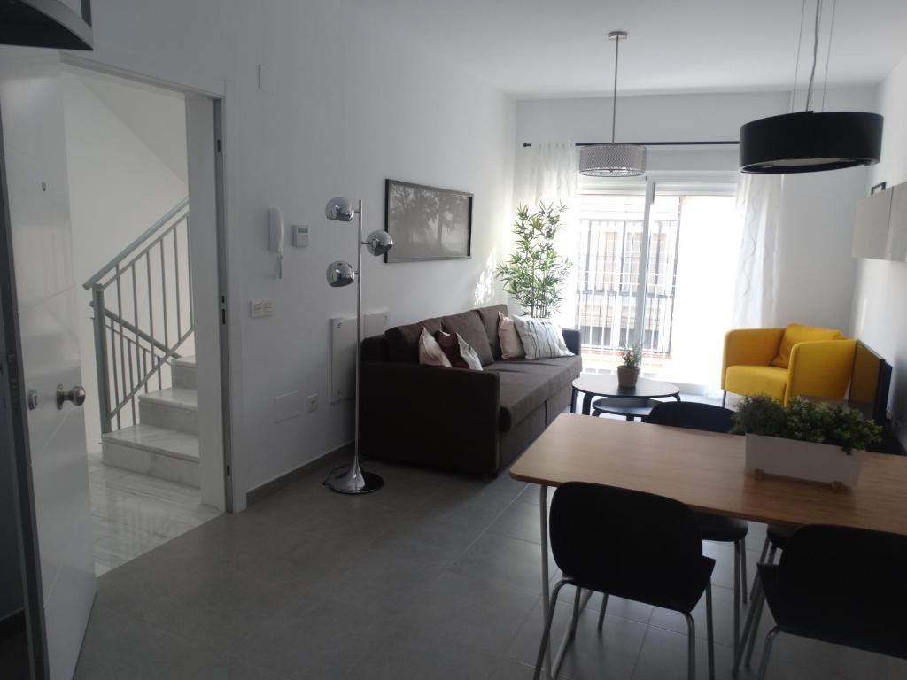 salon z kanapą i stołem w obiekcie Málaga Apartamentos - Jinetes, 10 w Maladze