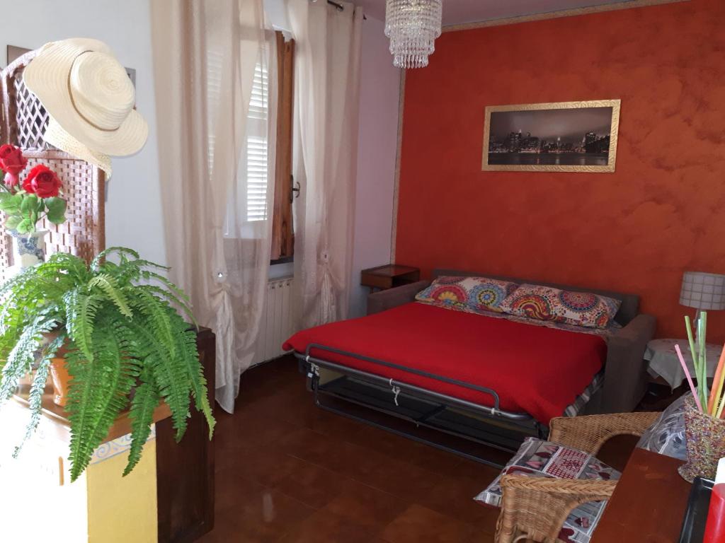 a living room with a couch and a red wall at Casa Lilly in Beverino