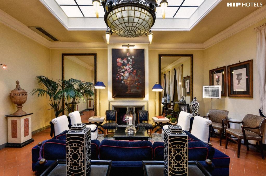 a living room with blue couches and a chandelier at Cellai Hotel Florence in Florence