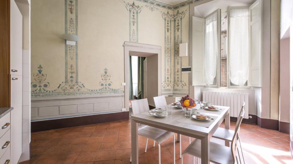 comedor con mesa blanca y sillas en siena centro, civetta, en Siena