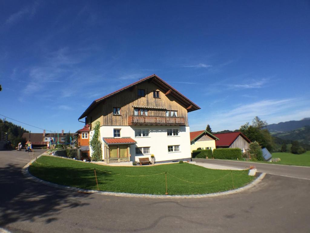 duży biały dom z drewnianym dachem w obiekcie Ferienhof Prinz w mieście Oberreute