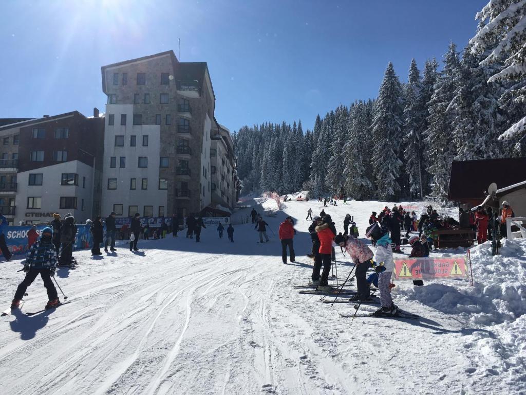 un grupo de personas esquiando en una pista cubierta de nieve en Stenata Huge Ski To Door Apartment, en Pamporovo