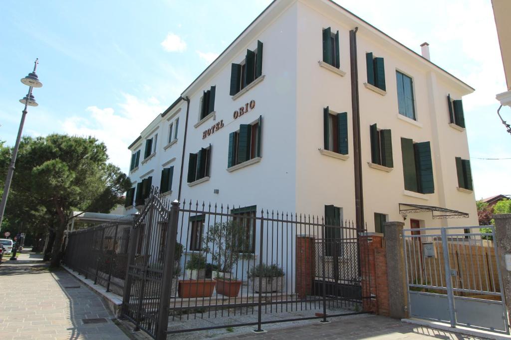 een wit gebouw met een hek ervoor bij Hotel Villa Orio e Beatrice in Venetië-Lido