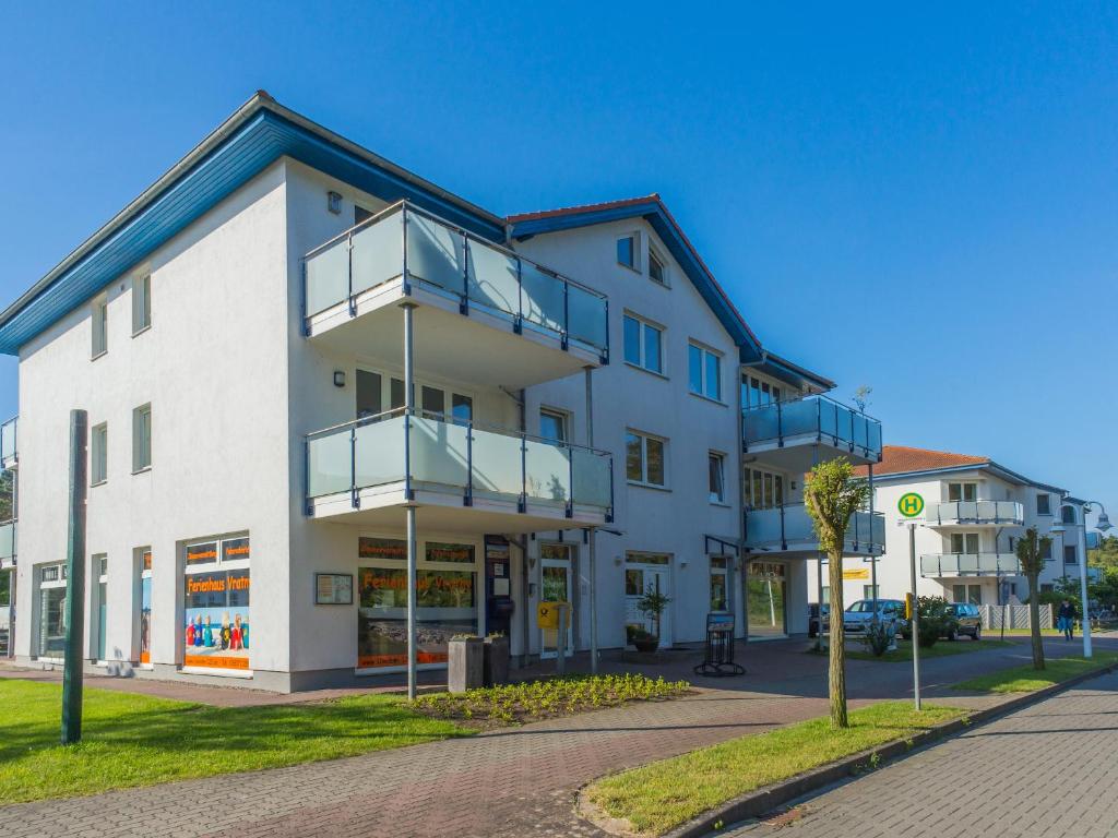 a white building with balconies on a street at Ferienhaus am Maiglöchchenberg 5 in Ostseebad Karlshagen