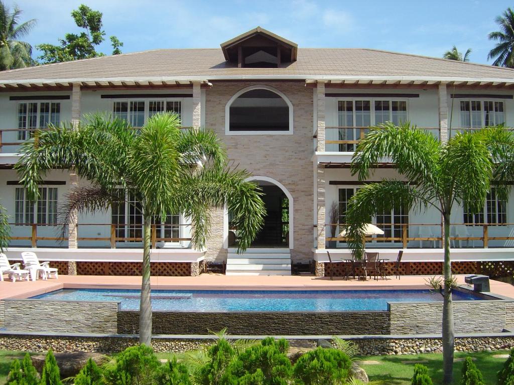 a house with a swimming pool and palm trees at Samui Manor House Apartments in Ban Bang Po