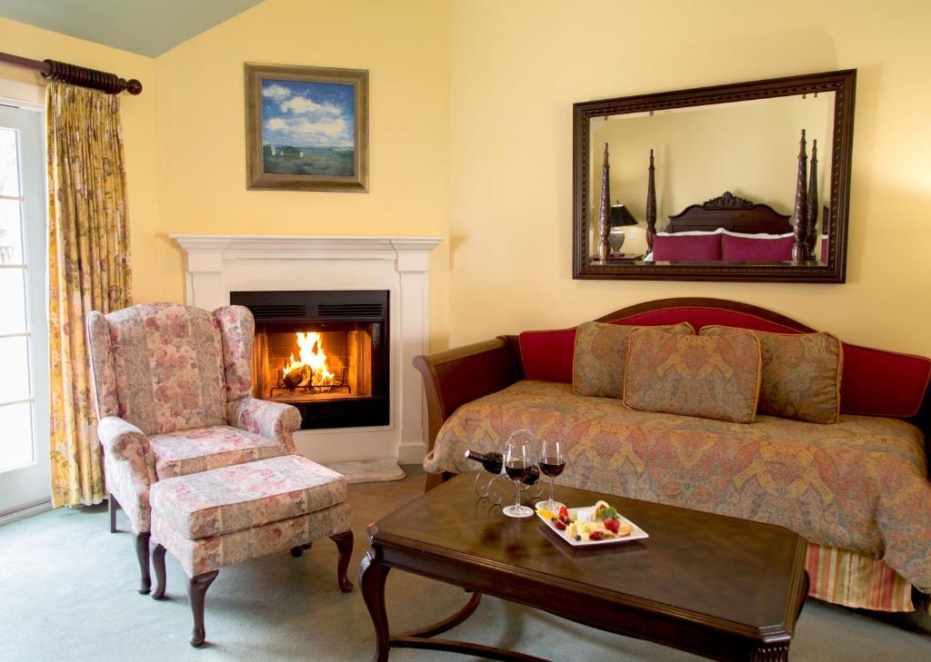 a living room with a bed and a fireplace at Queen Anne Inn in Chatham