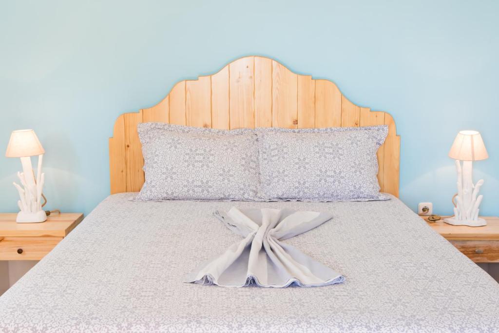 a large bed with a white bow on it at Sofia´s rooms in Kyra Panagia