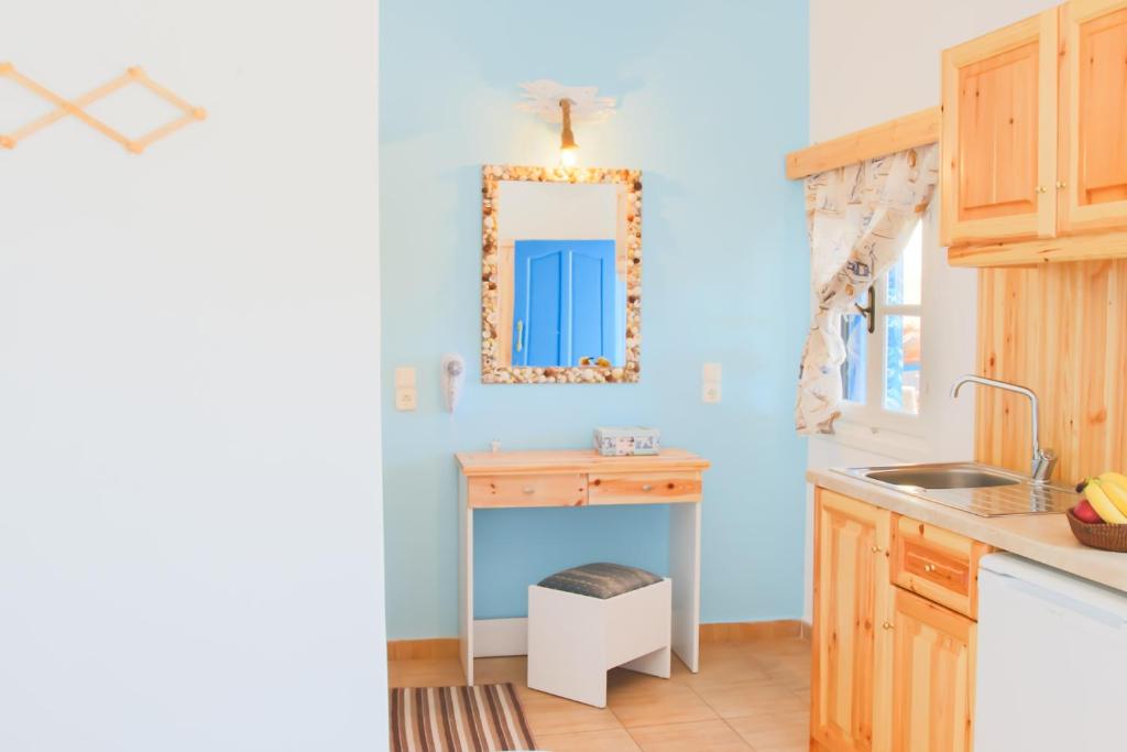 kuchnia z niebieskimi ścianami, umywalką i lustrem w obiekcie Sofia´s rooms w mieście Kyra Panagia