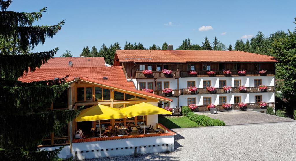 ein Gebäude mit einem gelben Regenschirm davor in der Unterkunft Landhotel Tannenhof in Spiegelau
