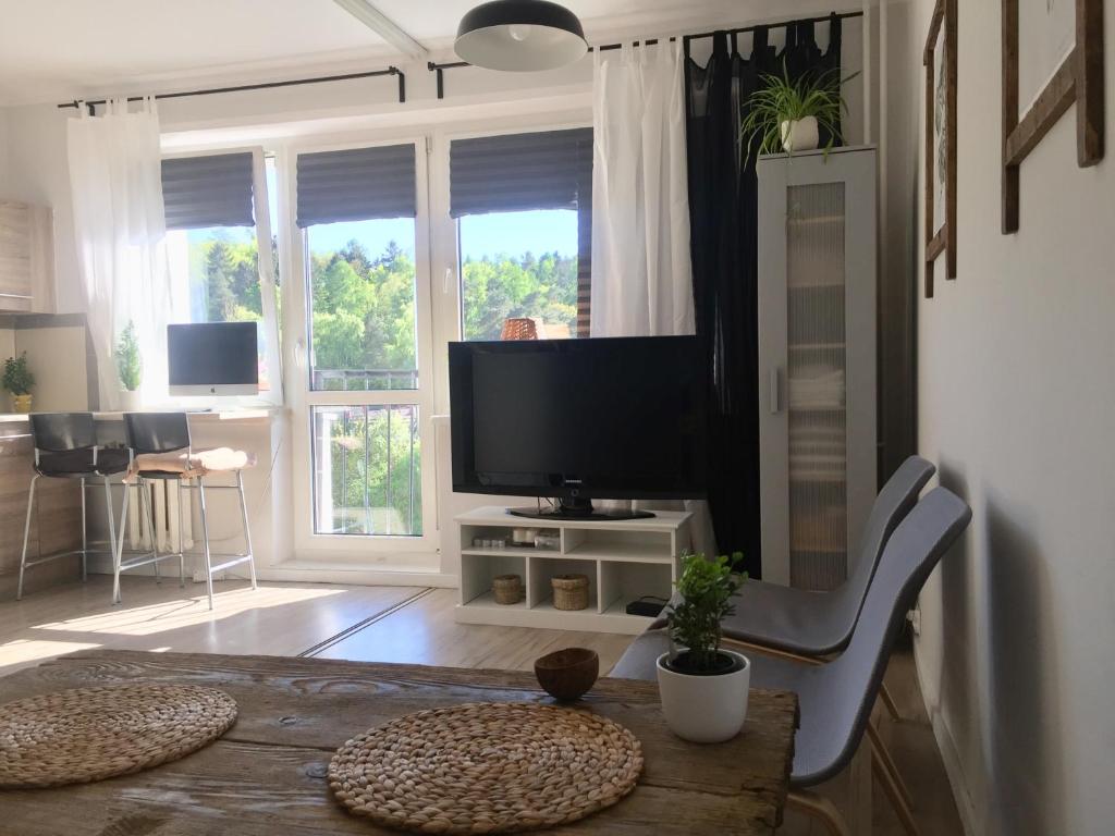 uma sala de estar com uma televisão e uma mesa com uma mesa de sidx em Apartament la mar em Sopot