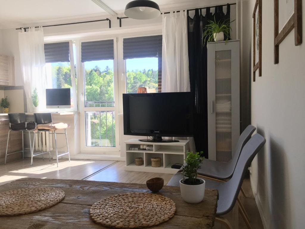 een woonkamer met een televisie en een tafel met een tafel sidx sidx bij Apartament la mar in Sopot