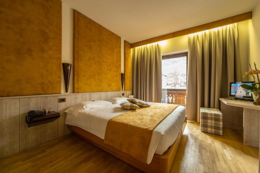 a bedroom with a large bed and a television at Hotel Comtes De Challant Albergo Etico Valle d'Aosta in Fenis