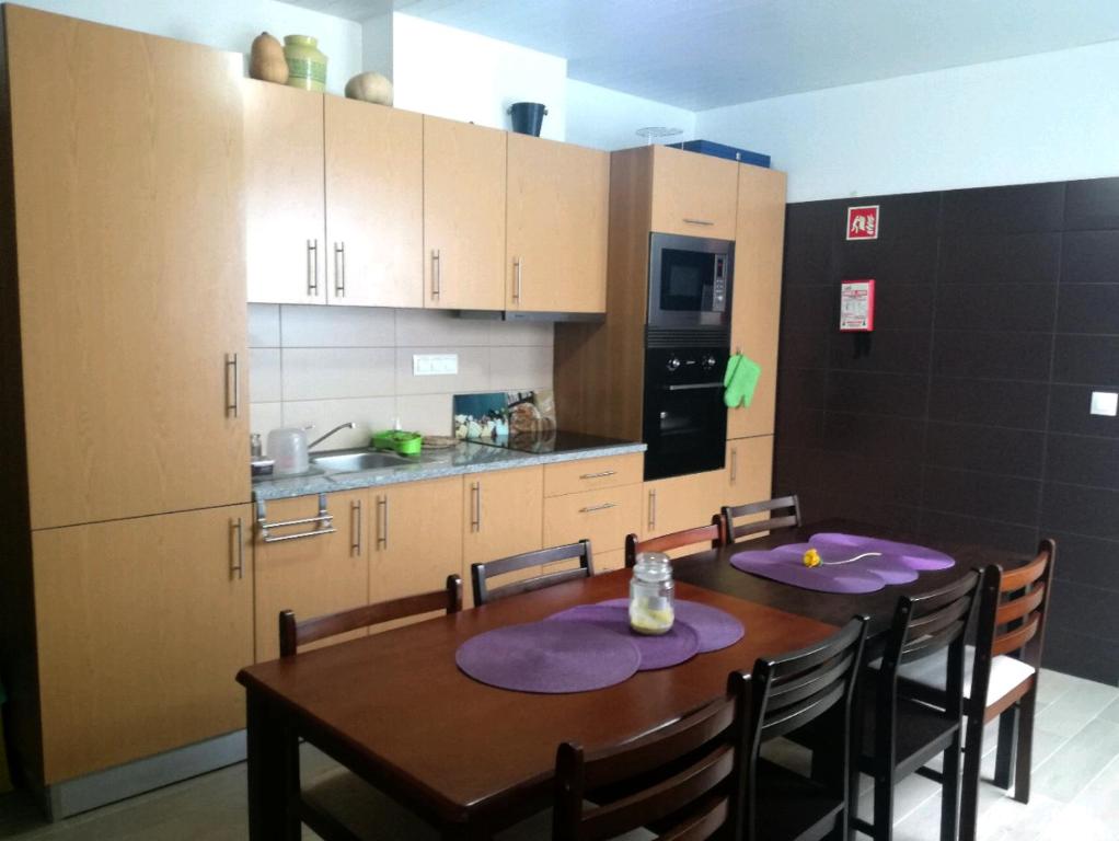 a kitchen with a table with purple plates on it at Pés Verdes-Alojamento e Chá in Ponta Delgada