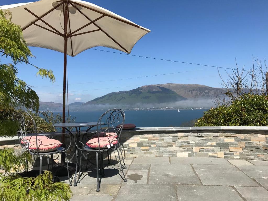 a table and two chairs with an umbrella at Carlingford Sea Cottage in Carlingford