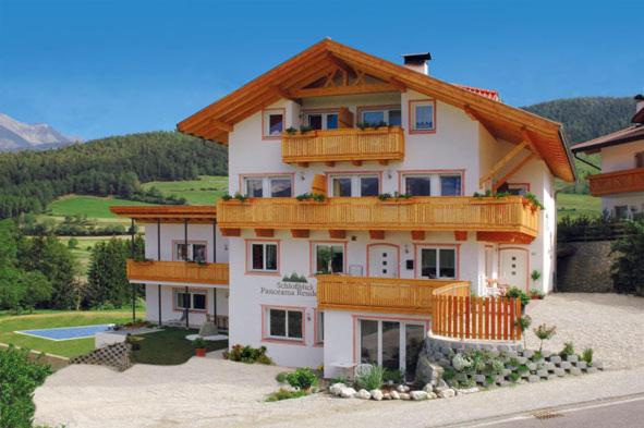 a large white building with a wooden roof at Panorama Residence Schlossblick in Rodengo