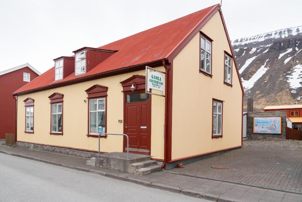 un piccolo edificio con tetto rosso su una strada di Guesthouse Gamla a Ísafjörður