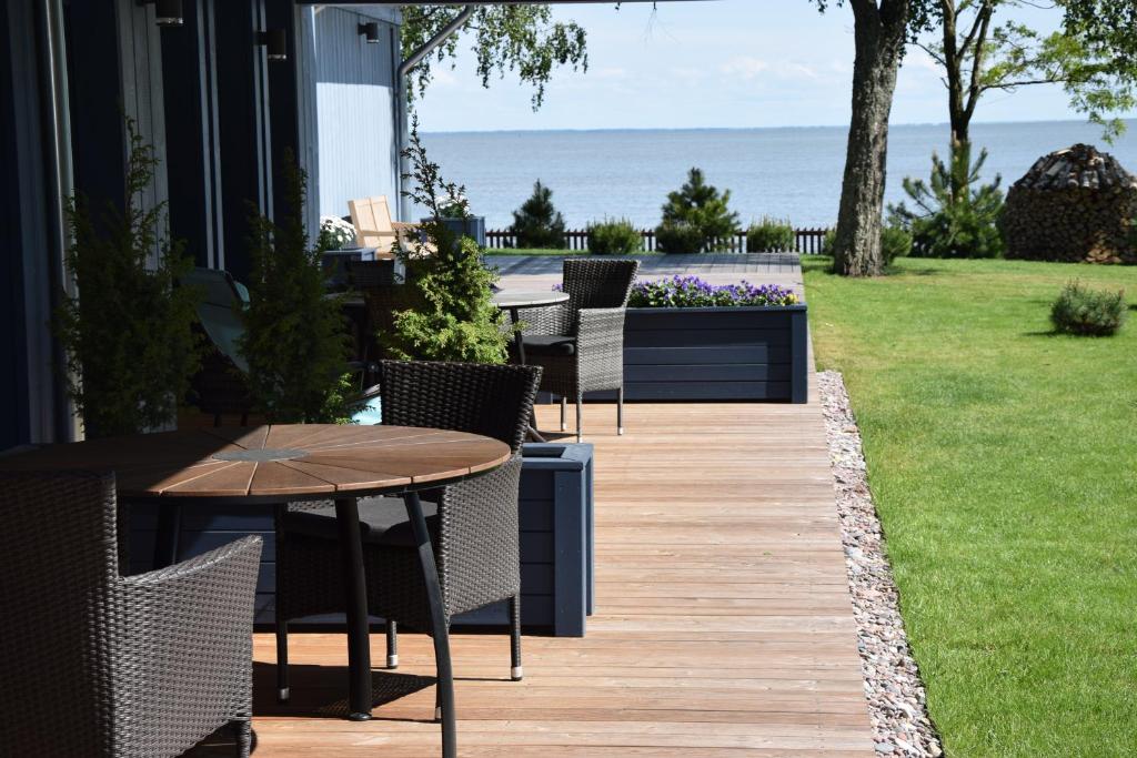 a patio with a table and chairs and the ocean at Marių pelėdos in Preila