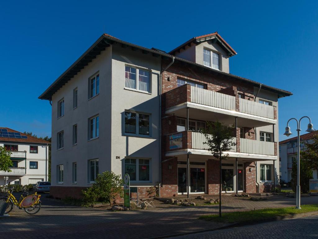 オストゼーバート・カールスハーゲンにあるFerienhaus - Strandstr. 24の通りに面したバルコニー付きの高いレンガ造りの建物