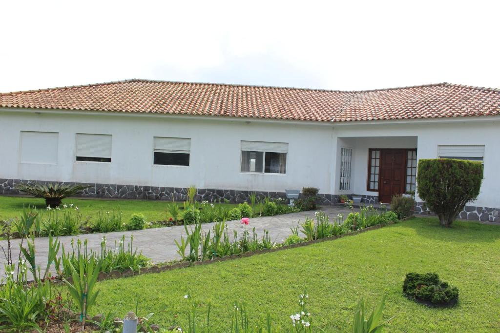 ein weißes Haus mit einem Garten davor in der Unterkunft Casa Branca in Lagoa
