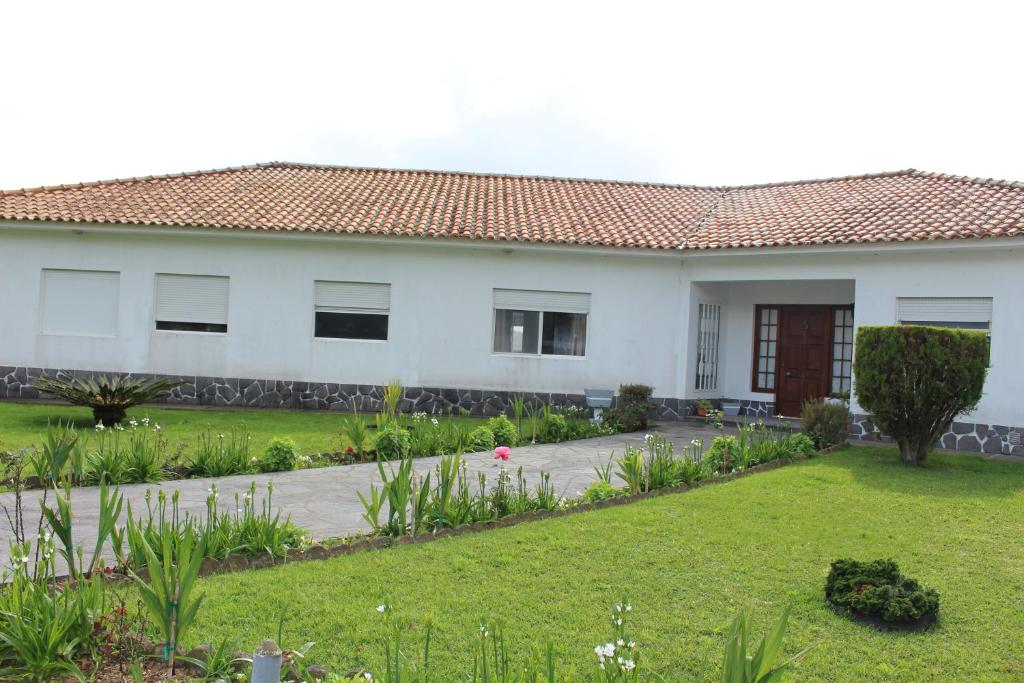 a white house with a garden in front of it at Casa Branca in Lagoa