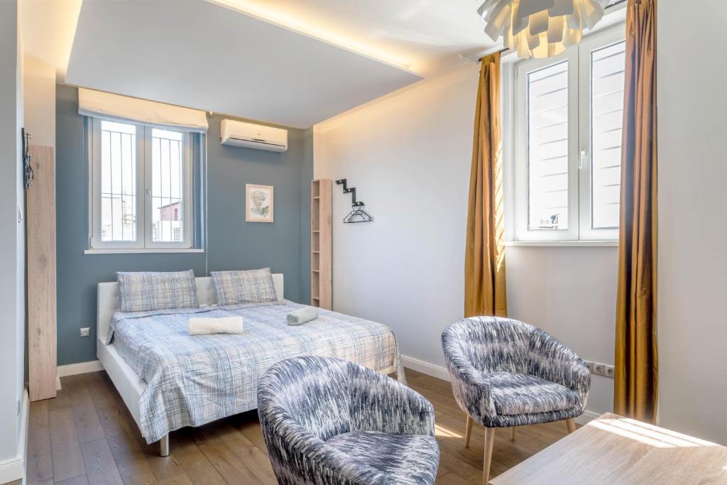 - une chambre avec un lit et deux chaises dans l'établissement Top of the city Apartment with AC, à Budapest