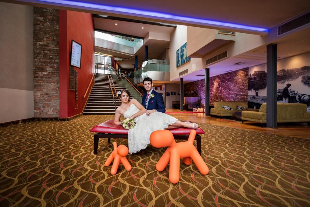 una sposa e uno sposo seduti su un tavolo in una stanza di Absolute Hotel Limerick a Limerick