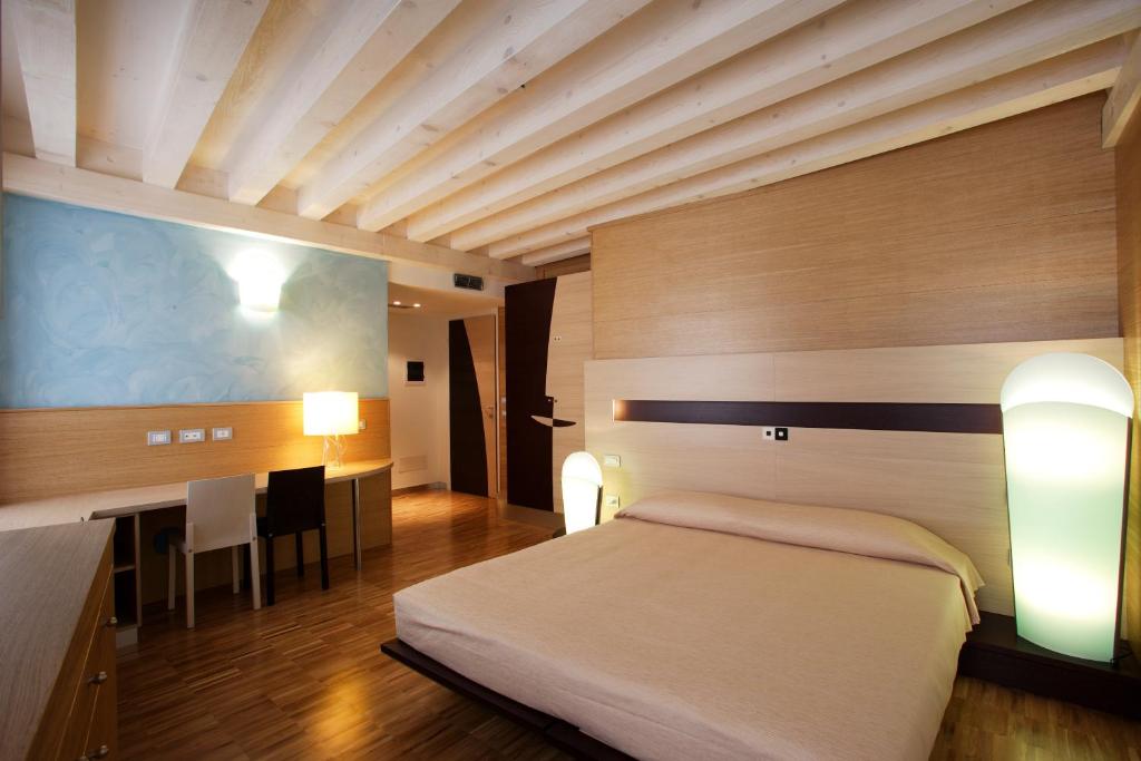 een slaapkamer met een bed, een bureau en een tafel bij Allegria in Udine