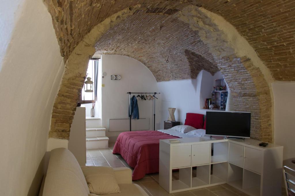 ein Schlafzimmer mit einem Bett und einem TV in einem Zimmer in der Unterkunft Antiche Mura in Irsina