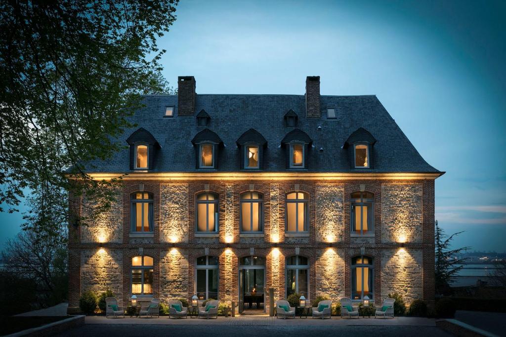 
a large building with a clock on the front of it at Le Manoir de la Plage / Adults Only in Honfleur
