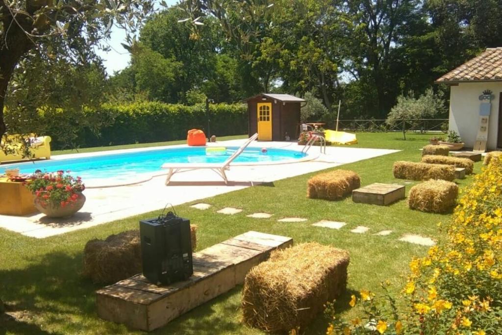 a backyard with a swimming pool with bales of hay at Gino's House in Gubbio