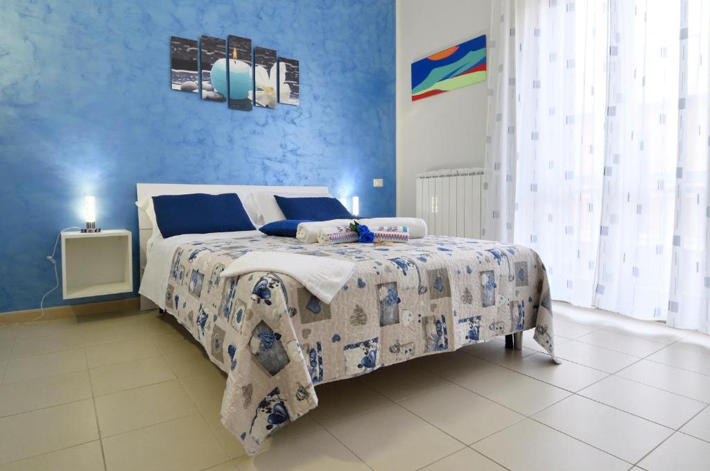 a bedroom with a bed with a blue wall at Malo' Rooms in Termoli