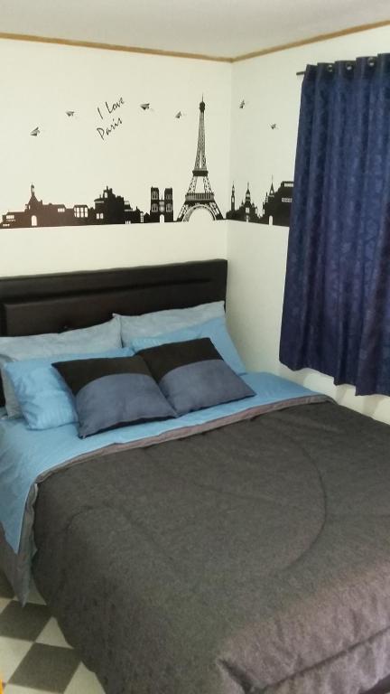 1 dormitorio con 1 cama con la torre Eiffel en La Casa De Huespedes, en Bogotá