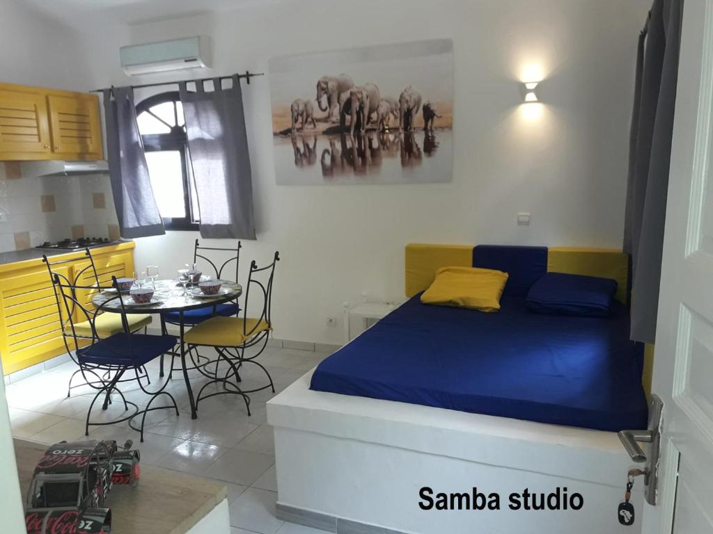 a bedroom with a bed and a table with chairs at Studio Samba in Saly Portudal