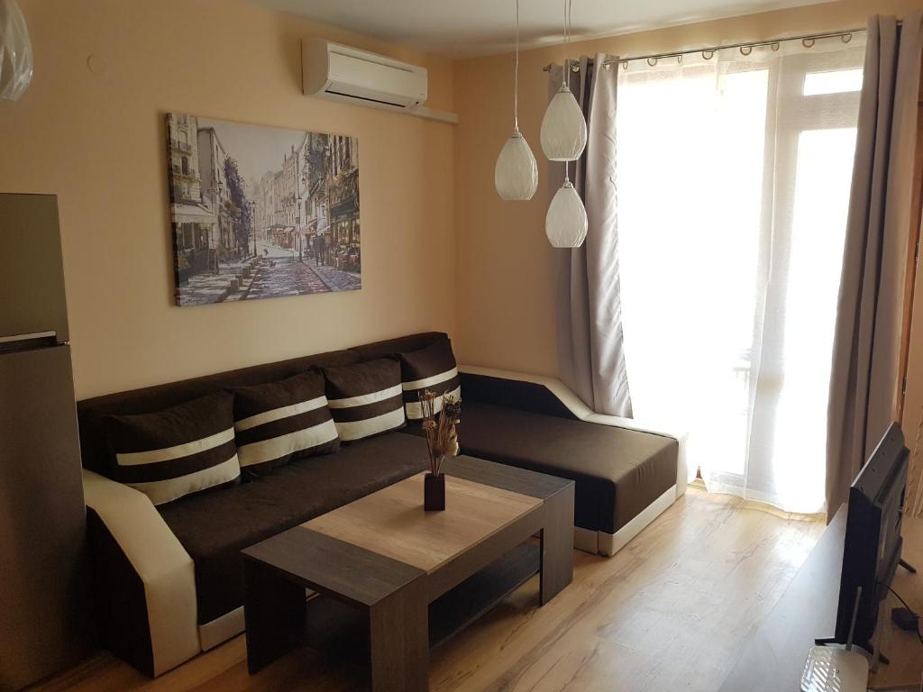 ein Wohnzimmer mit einem Sofa und einem Couchtisch in der Unterkunft Victorio Lux Apartments in Sweti Wlas