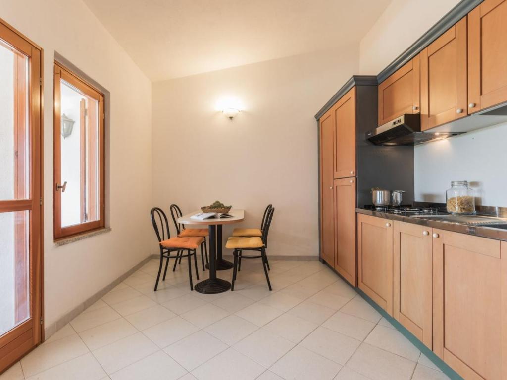 a kitchen with a table and chairs in a room at Capo Ceraso Family Resort in Costa Corallina