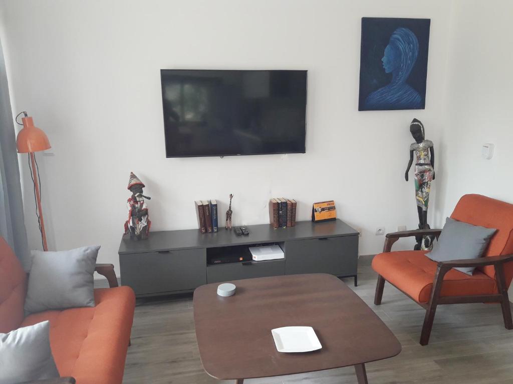 a living room with a flat screen tv on a wall at Studio Sunshine in Saly Portudal