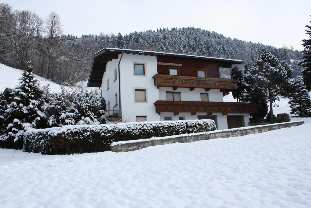 a building with snow on the ground in front of it at Landhaus Johannes in Hart im Zillertal