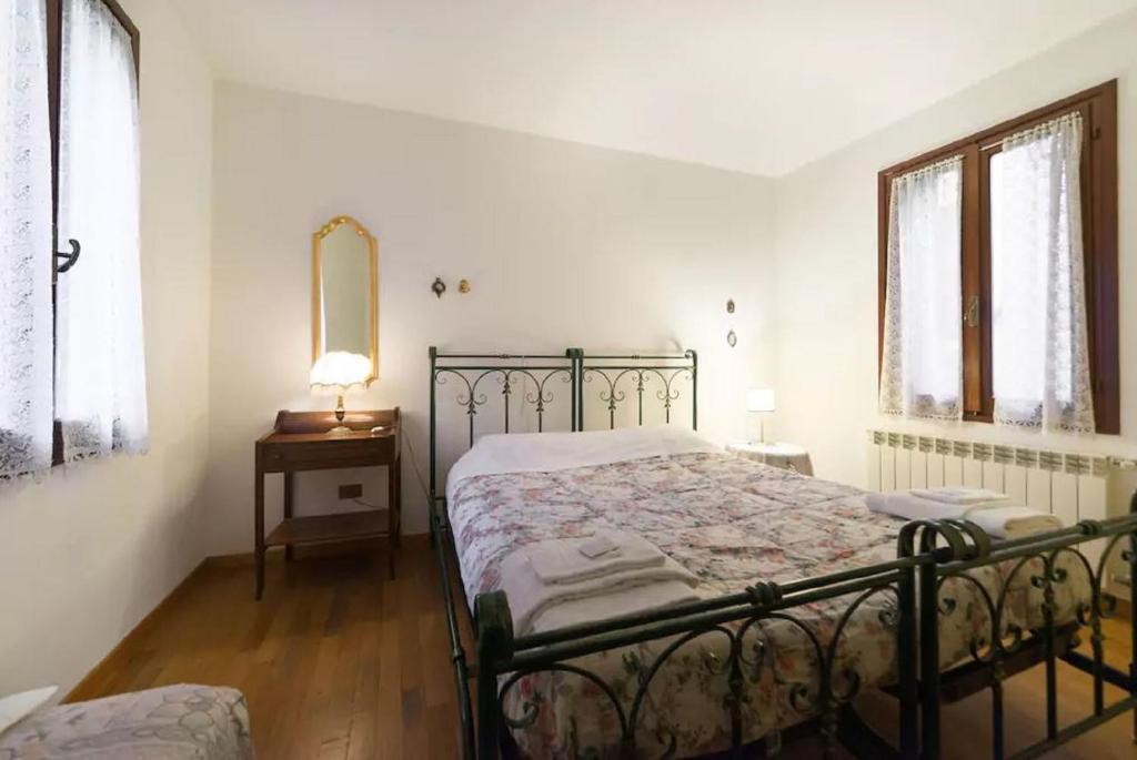 a bedroom with a bed and a table and a mirror at San Barnaba Artist's district house in Venice