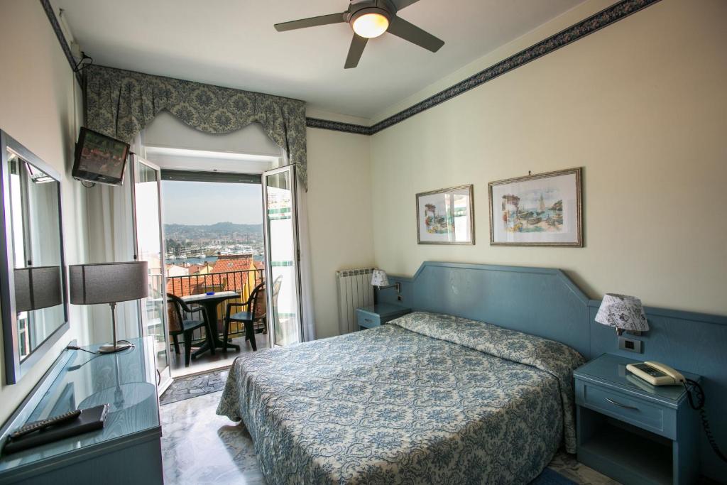 a bedroom with a blue bed and a balcony at Hotel Ariston in Imperia