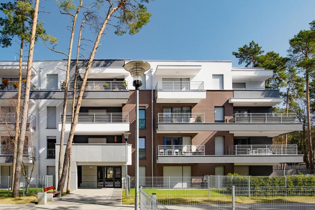 un immeuble d'appartements avec balcon et arbres dans l'établissement Blue Baltic, à Pogorzelica