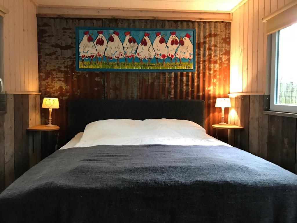 een slaapkamer met een bed en een schilderij aan de muur bij De Flierefluiter in Nutter