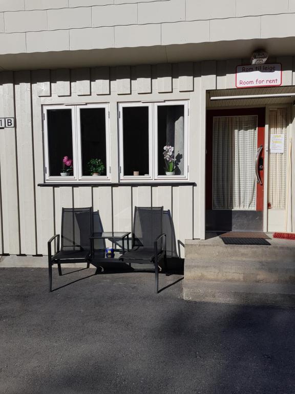 zwei Stühle vor einem Gebäude mit Fenstern in der Unterkunft Leilighet i Åmotsdal in Kyrkjemoen